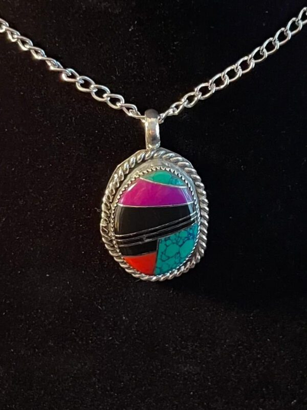 A colorful stone is on the silver chain.