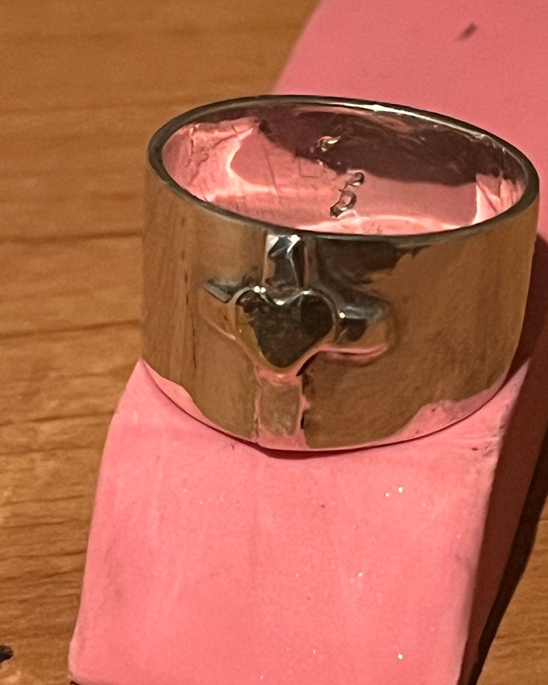 A silver ring with a heart on it