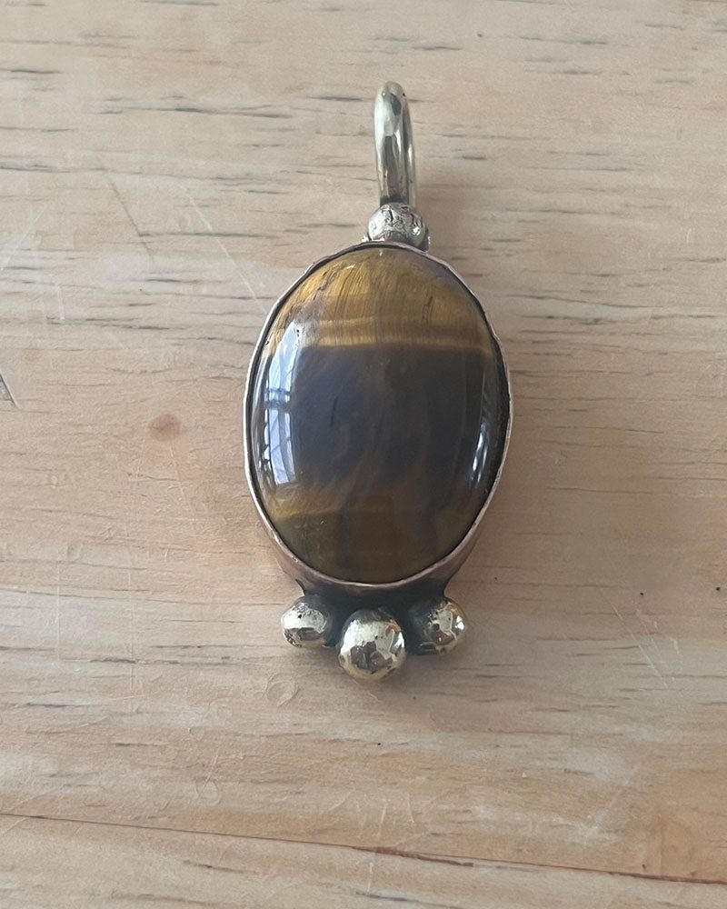 A tiger 's eye stone is sitting on top of a wooden table.