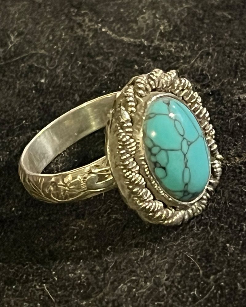 A turquoise ring is shown on the ground.