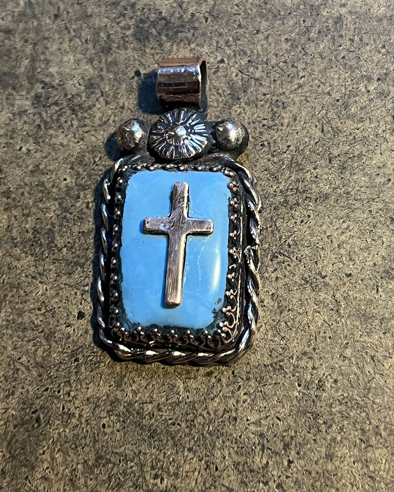 A cross is shown on the side of a blue stone.
