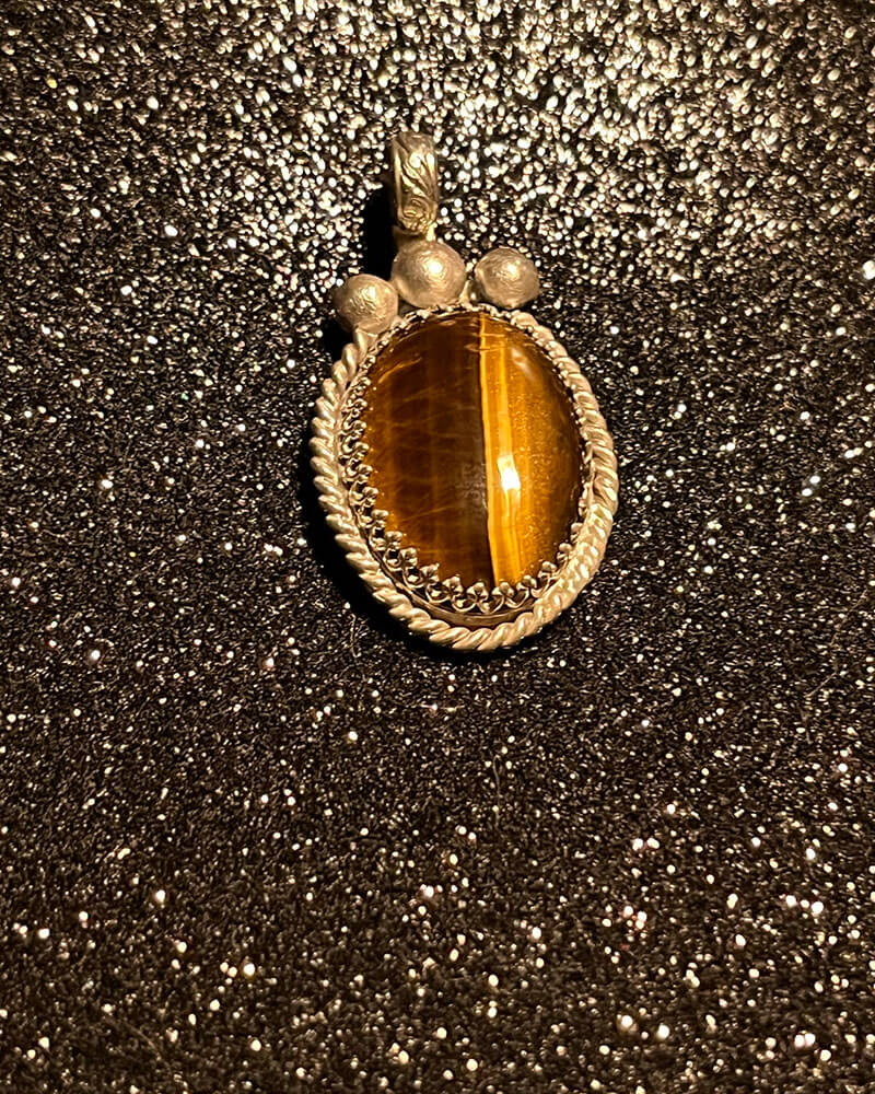 A tiger eye stone is sitting on the ground.