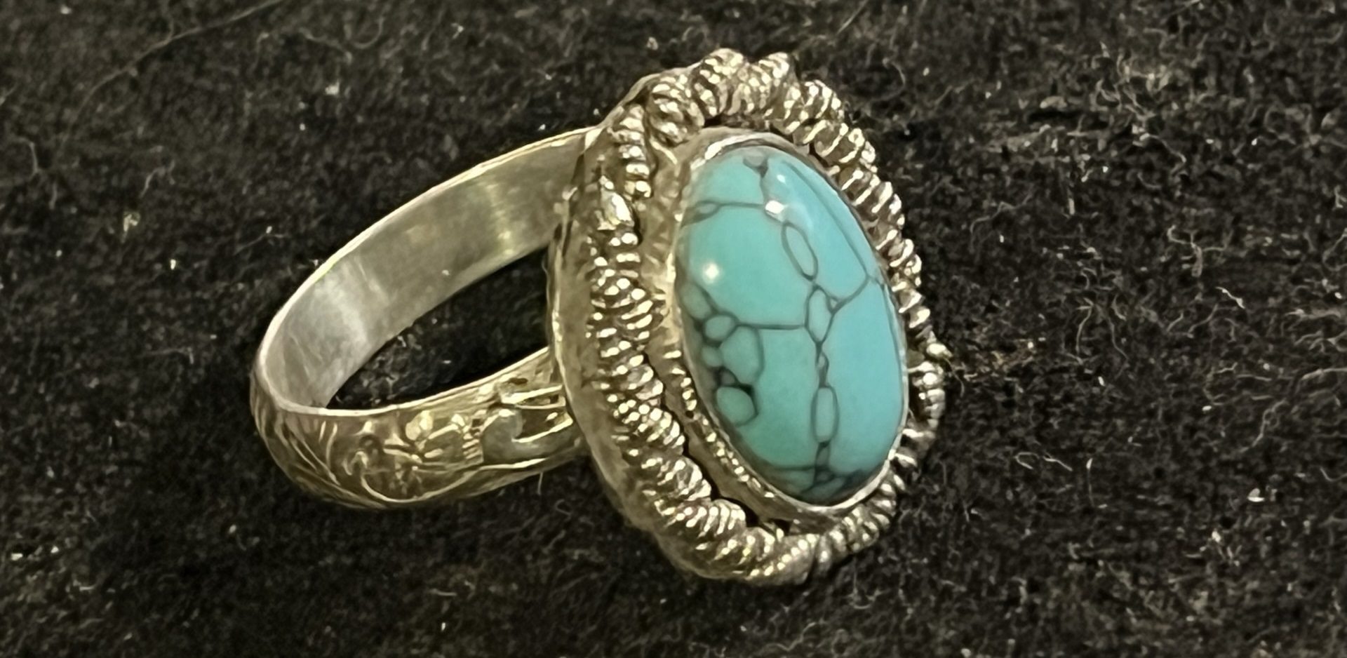 A silver ring with a turquoise stone on it.