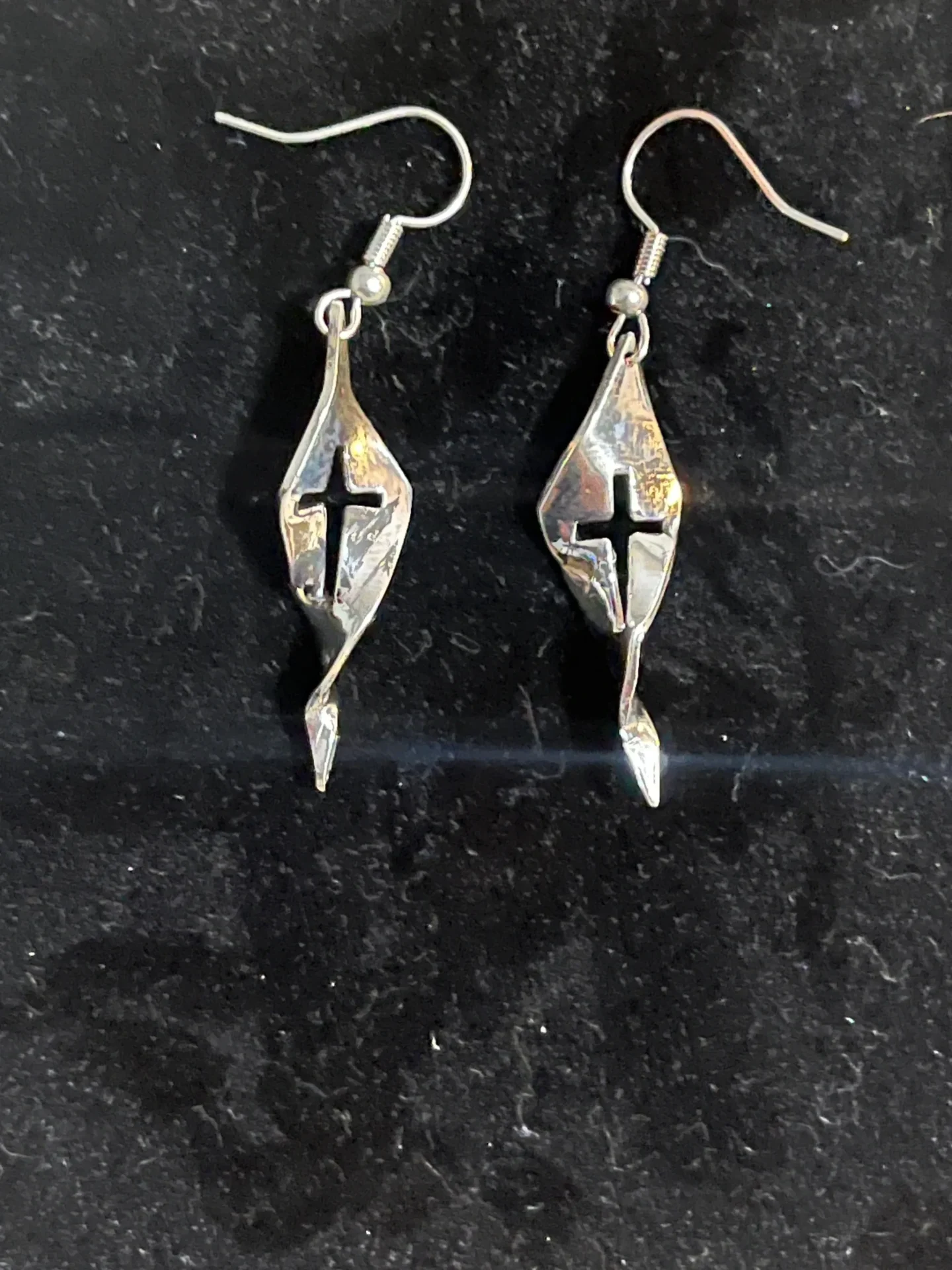 A pair of earrings with a cross on them.