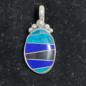 A blue and black pendant is shown on the ground.
