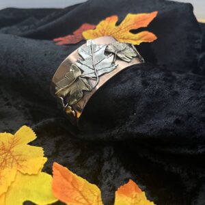 Copper bracelet with silver leaf design.