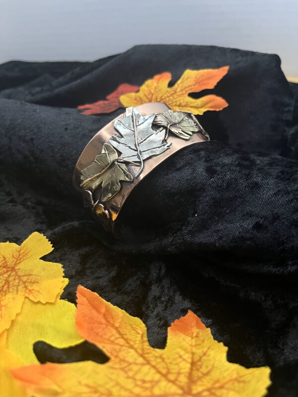 Copper bracelet with silver leaf design.