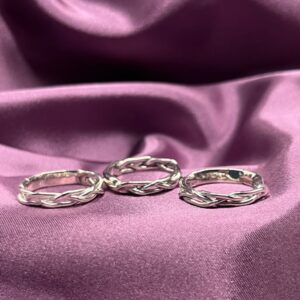 Three silver braided rings on fabric.